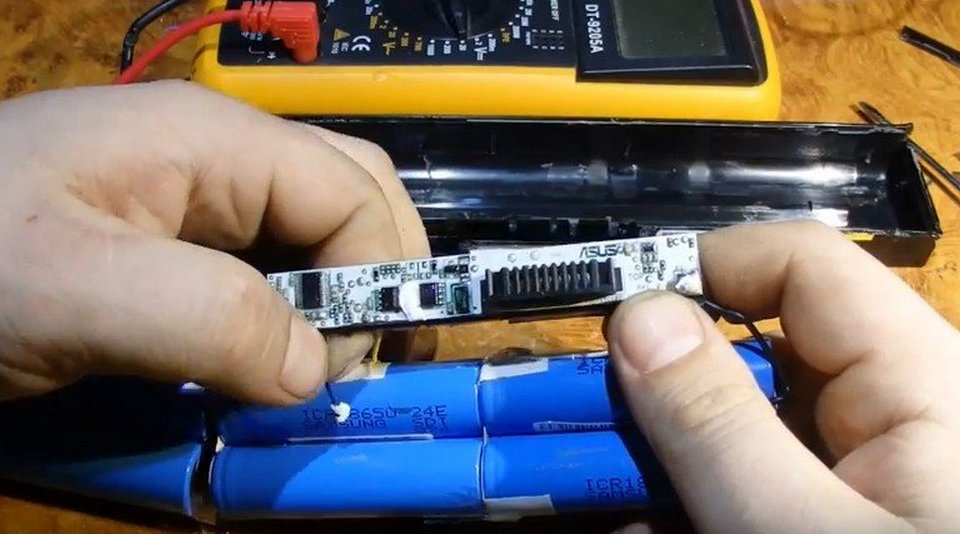 Мастер ремонтирует контроллер аккумулятора ноутбука